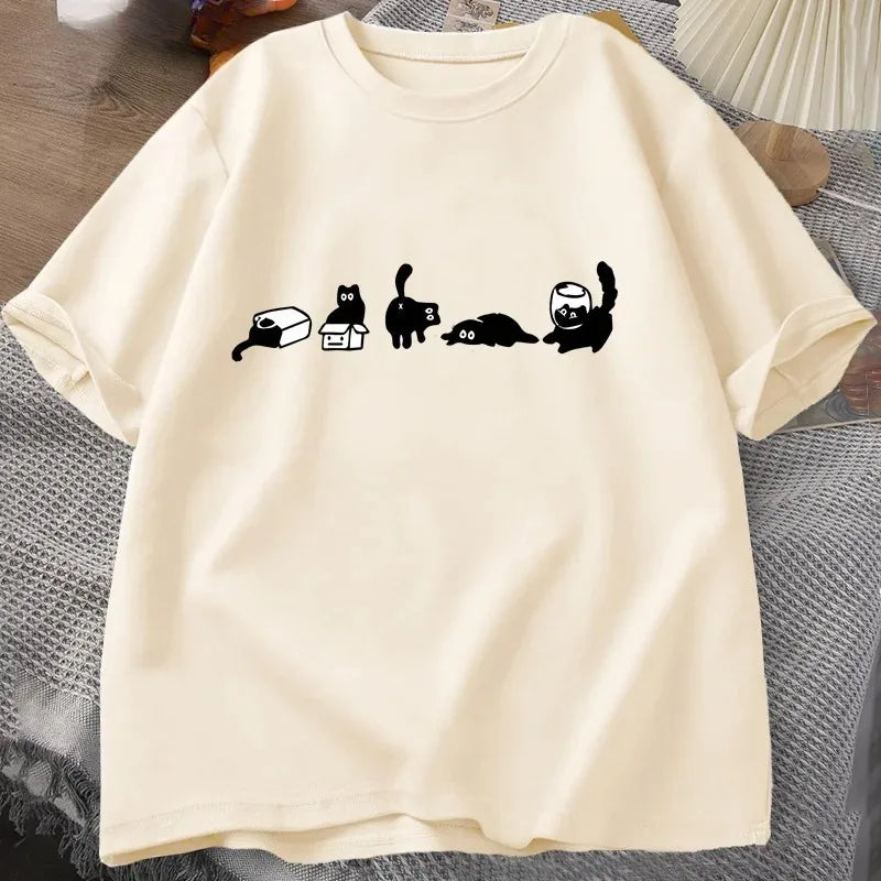 Beige t-shirt with black cat illustrations on a textured surface