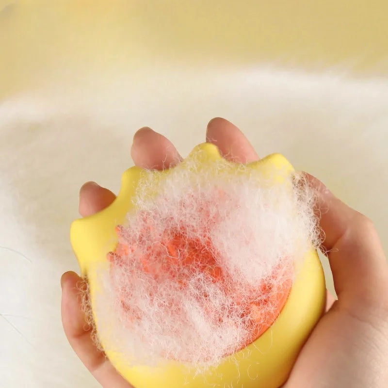Yellow sponge with foam held in a hand against a light background