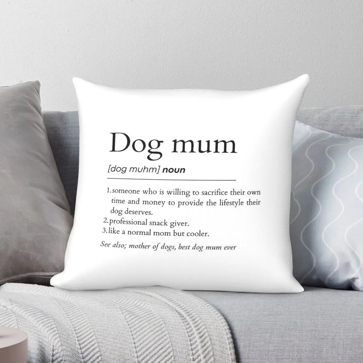 White pillow with text definition of 'Dog mum' on a gray couch.
