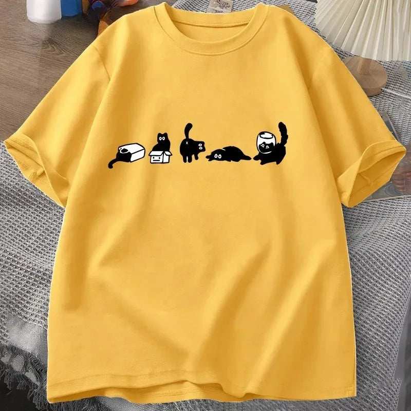 Yellow t-shirt with black cat illustrations on a textured surface
