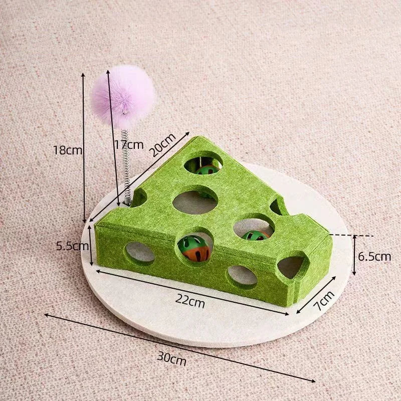 Green cat toy with holes and a purple ball on a beige background, showing measurements.