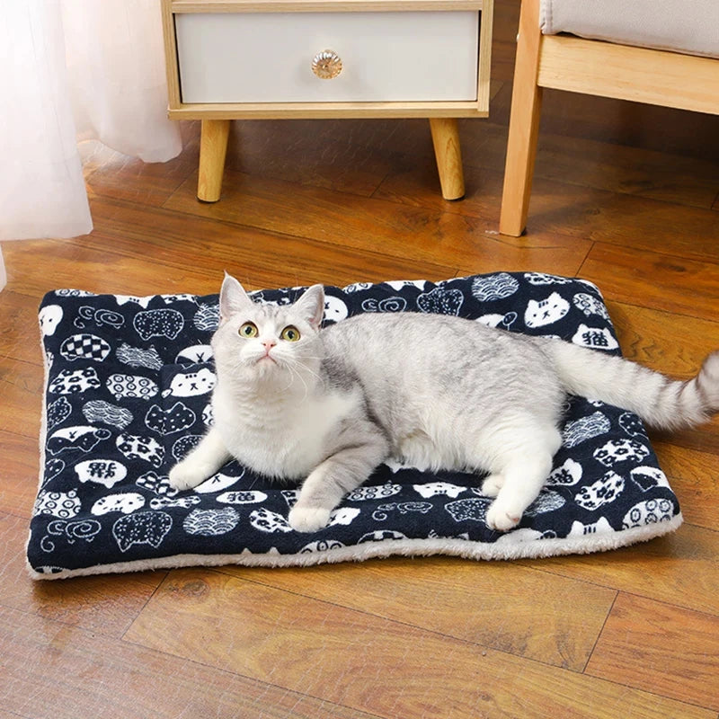 Cat lying on a patterned mat on a wooden floor