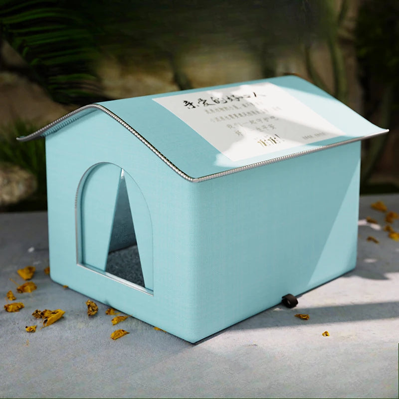 Light blue pet house-shaped box with a white label on a gray surface.