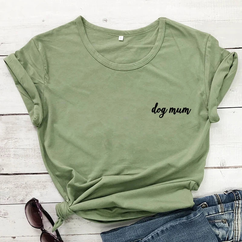 Green t-shirt with 'dog mum' text on a wooden surface with jeans and sunglasses.