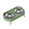 Green pet feeder with two stainless steel bowls on a white background
