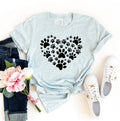 Light blue t-shirt with black paw print heart design, jeans, sneakers, and flowers on a white background