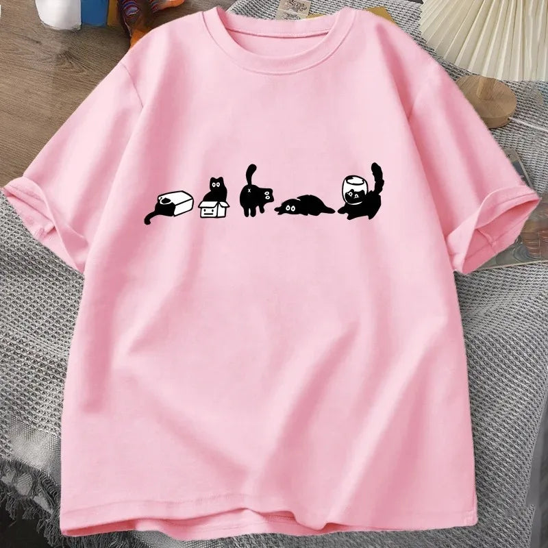 Pink t-shirt with black cat illustrations on a textured surface