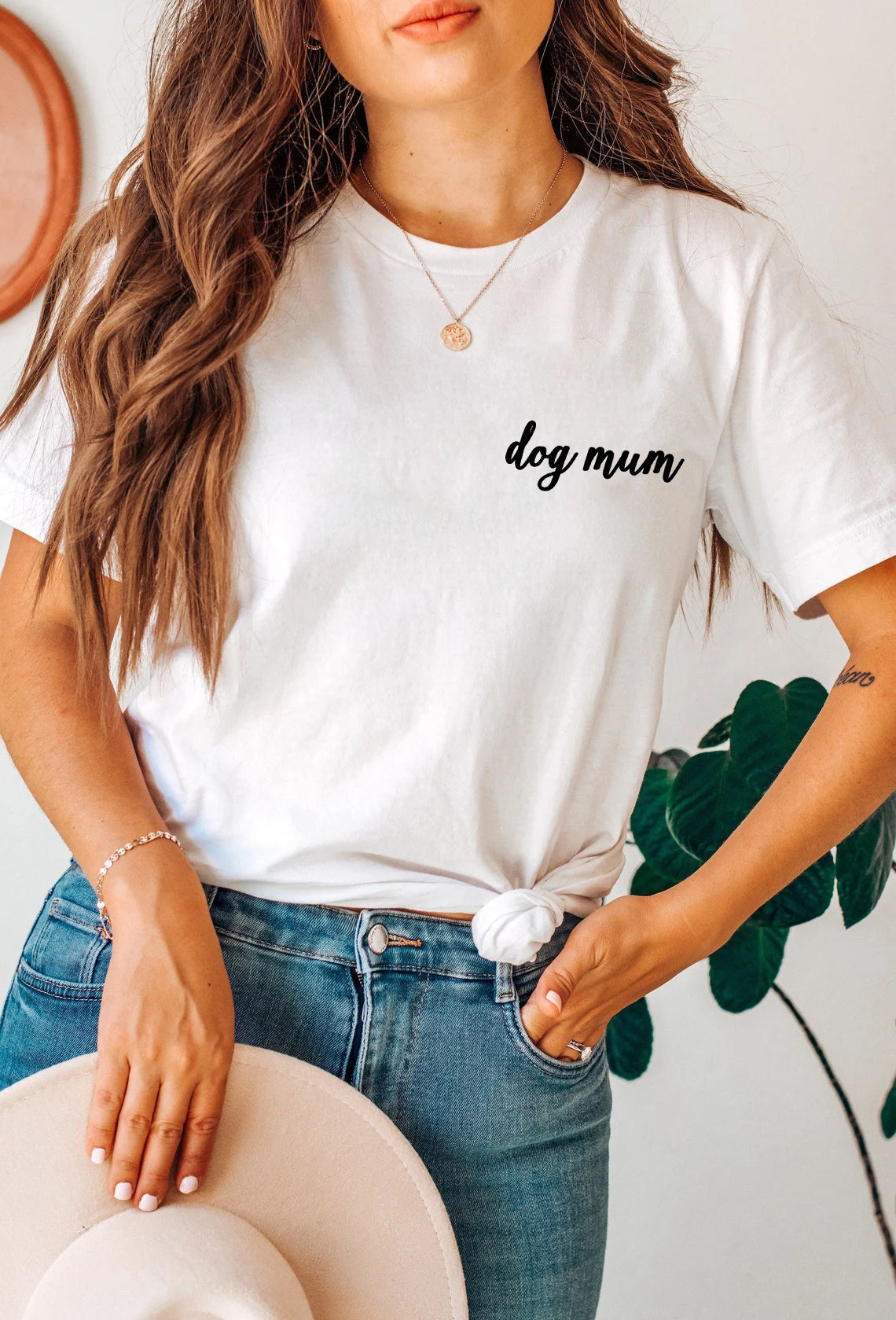 Person wearing a white t-shirt with 'dog mum' text, standing indoors.